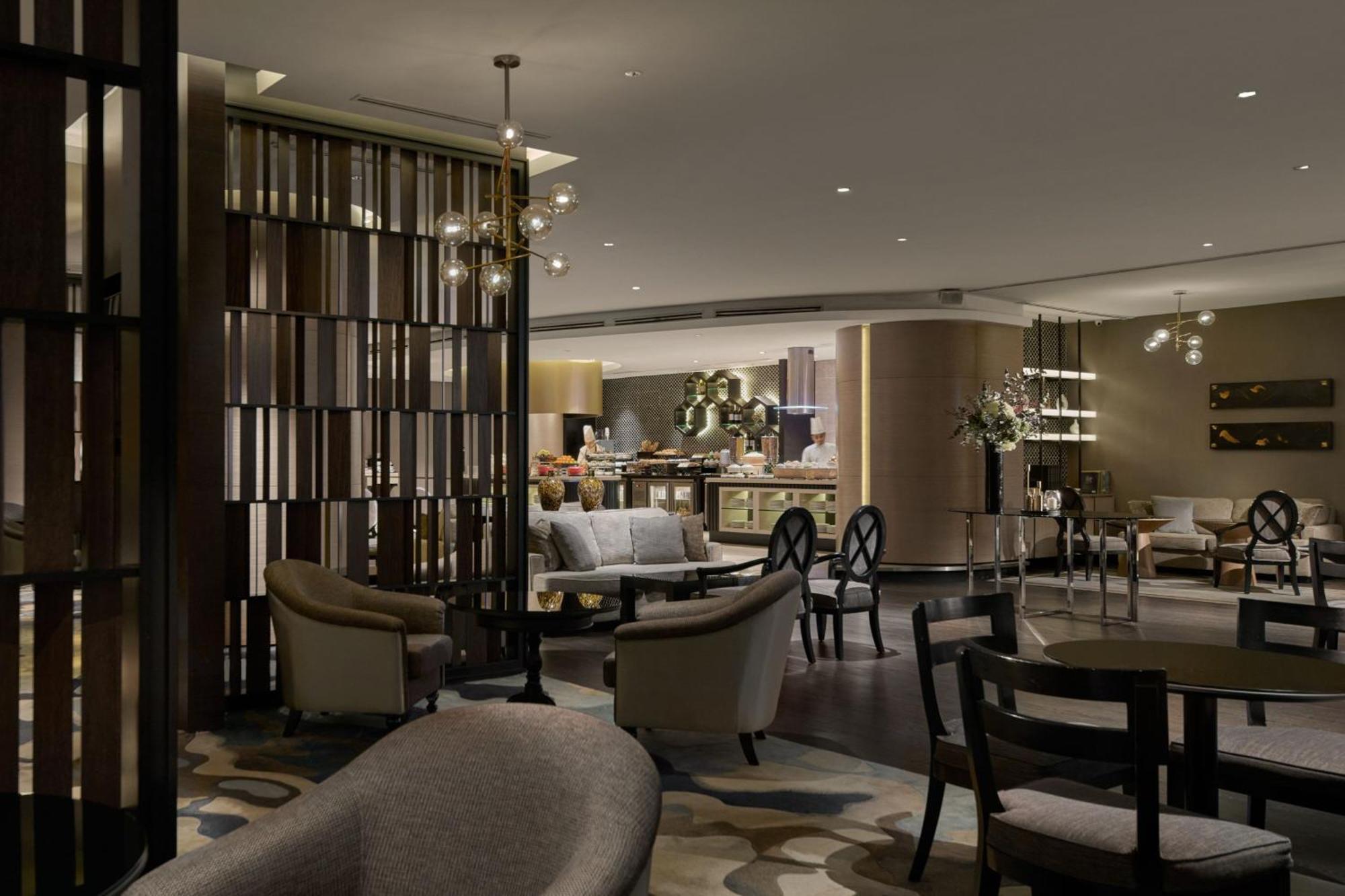 Отель Jw Marriott Куала-Лумпур Экстерьер фото The image shows a modern and stylish interior of a lounge or a hospitality space. It features a combination of comfortable seating options, including plush chairs and sofas arranged around tables. The decor is elegant, with soft lighting creating a w