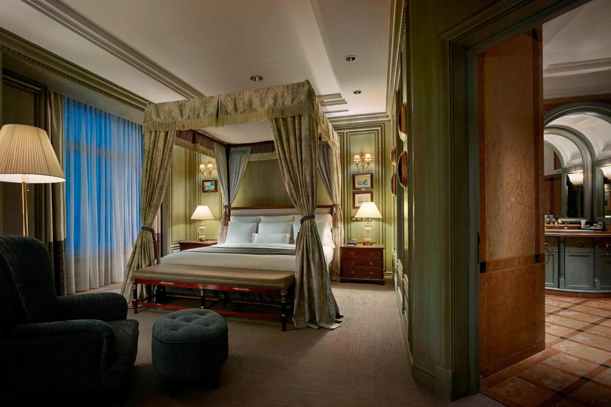 Отель Jw Marriott Куала-Лумпур Экстерьер фото The photo depicts a luxurious bedroom featuring a four-poster bed draped with elegant curtains. The bed is positioned against a wall with soft, muted colors, creating a calming atmosphere. On either side of the bed, there are bedside tables with lamp
