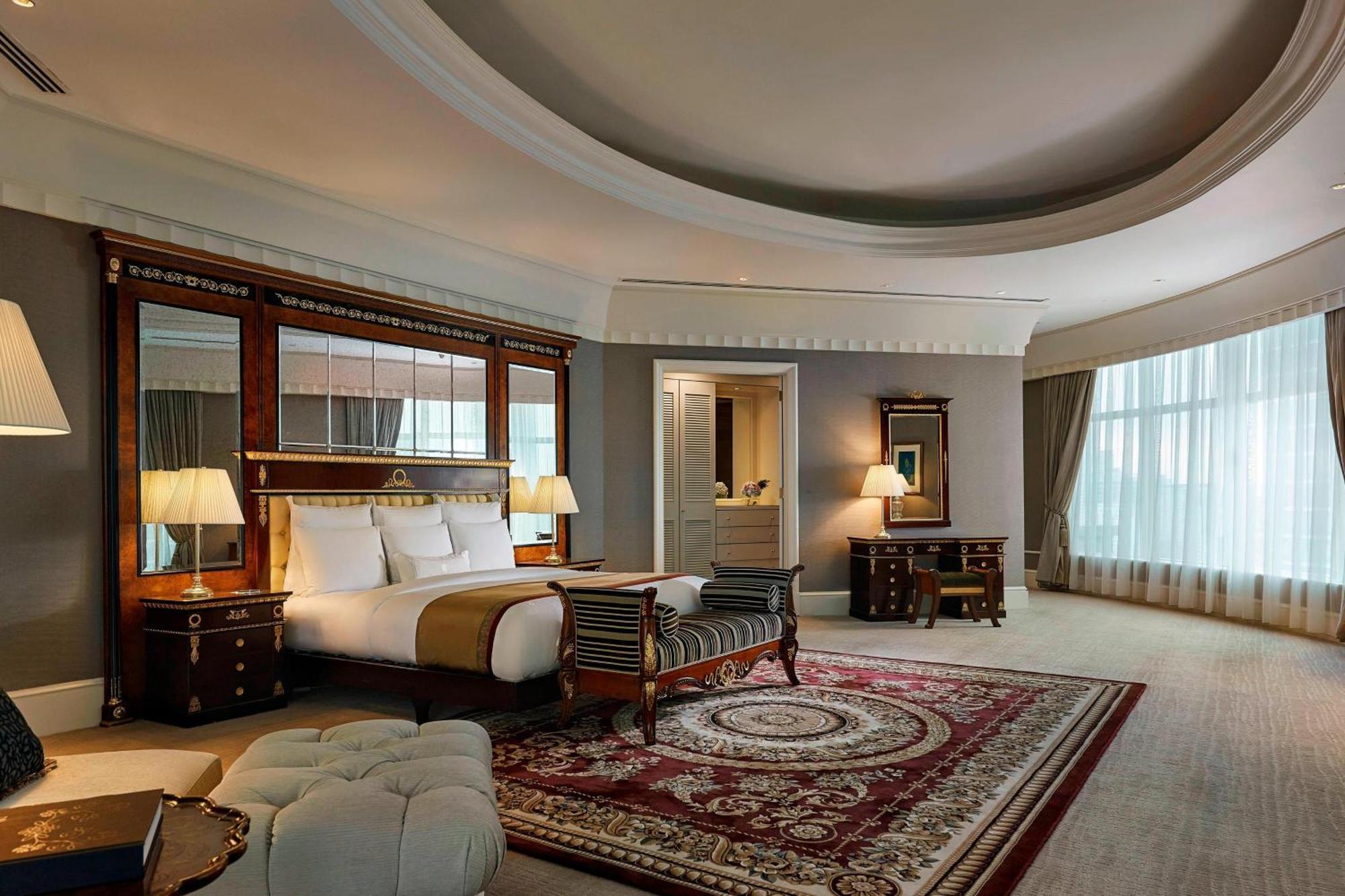 Отель Jw Marriott Куала-Лумпур Экстерьер фото The photo shows an elegant hotel room with a luxurious design. It features a large king-size bed with white linens, flanked by stylish bedside lamps. There is a decorative mirror behind the bed that adds depth to the space. The room includes a plush 