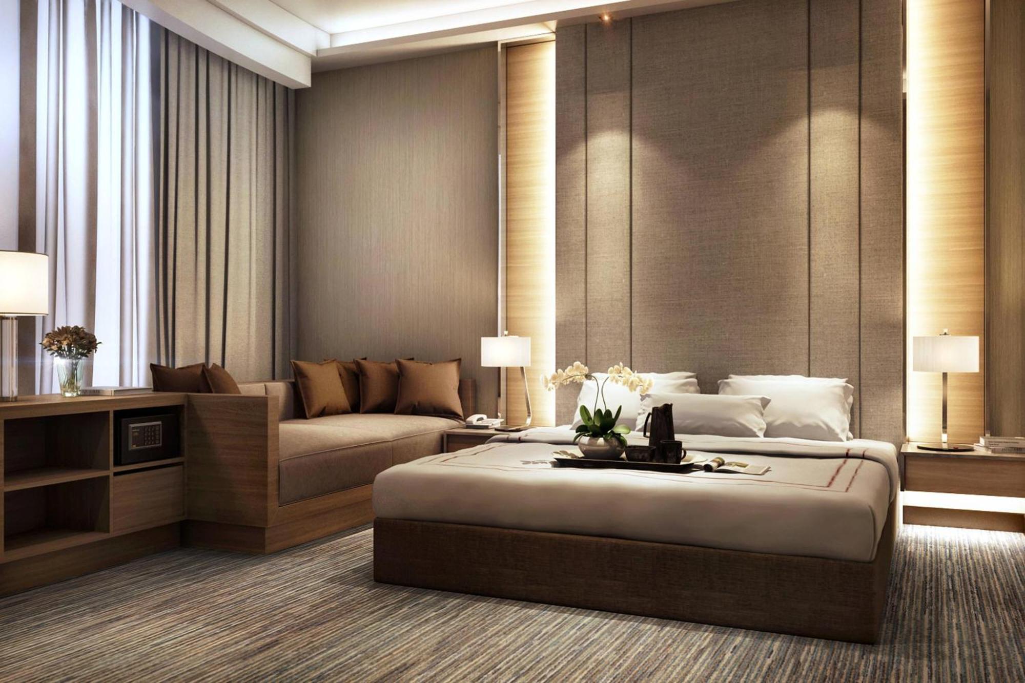 Отель Jw Marriott Куала-Лумпур Экстерьер фото The photo depicts a modern and stylish bedroom. It features a large bed with neutral-colored bedding and an elegant headboard. On either side of the bed, there are bedside tables with contemporary lamps. There's a cozy seating area with a sofa adorne